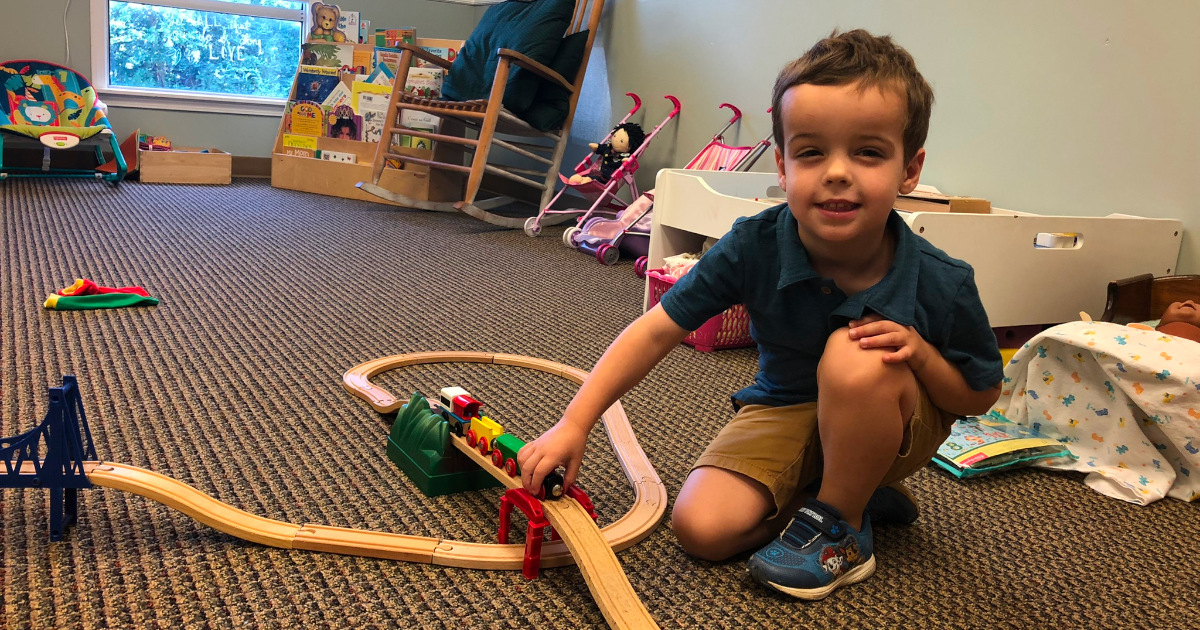 2022 photo of child playing with a toy train in the nursery